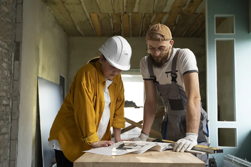Two professionals discussing renovation assistance for a residential property
